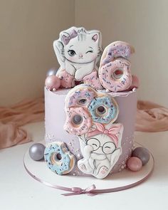 a three tiered cake decorated with donuts and cats