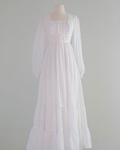 a white dress on a mannequin dummy with long sleeves and ruffles