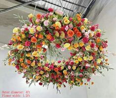 an arrangement of flowers is hanging from the ceiling