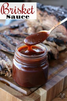 barbecue sauce being poured into a jar on a cutting board with ribs in the background