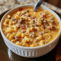 a white bowl filled with macaroni and cheese soup on top of a table