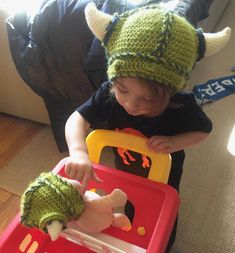 a child in a green knitted hat playing with a toy