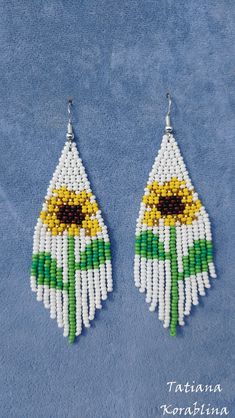 the beaded earrings are decorated with sunflowers and green, yellow and white beads