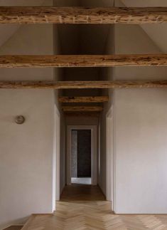 an empty room with wooden floors and beams on the ceiling is seen in this image