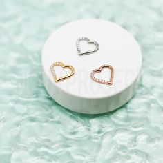 two heart shaped earrings sitting on top of a white plate