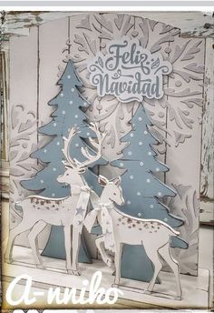 two deer standing next to each other in front of a wooden background with snowflakes