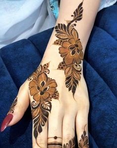 a woman's hand is decorated with hennap and flower designs on it