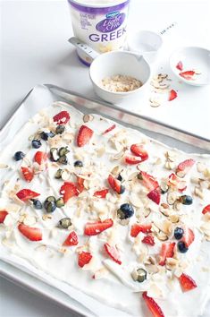 an ice cream dessert with strawberries, blueberries and almonds