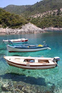 two small boats floating in clear blue water