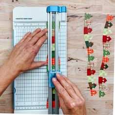 a person is cutting fabric on a piece of paper with scissors and rulers in front of them