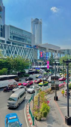 a busy city street filled with lots of traffic and tall buildings in the back ground