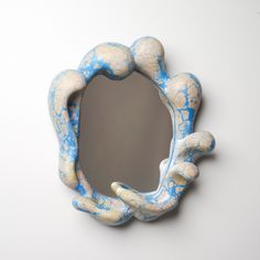 a blue and white hand holding a mirror