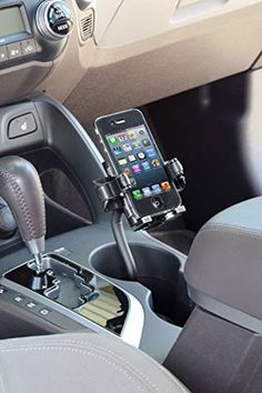 a car dashboard with a cell phone in the holder