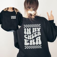 This In My Cheer Era Shirt is the perfect gift for any cheerleader! It's cute, comfy and aesthetic! This sweatshirt comes in both adult unisex sizes and youth sizes. Ideal for any situation, a unisex heavy blend crewneck sweatshirt is pure comfort. These garments are made from polyester and cotton. This combination helps designs come out looking fresh and beautiful. The collar is ribbed knit, so it retains its shape even after washing. There are no itchy side seams on these sweaters.  .: Made wi Trendy Crew Neck Top For Cheerleading, Casual Cotton Sweatshirt For Cheerleading, Long Sleeve Tops With Custom Print For Cheerleading, Cotton Sweatshirt With Letter Print For Cheerleading, Cheer Sweaters, School Spirit Graphic Print Sweatshirt For Cheerleading, Cheer Era Shirt, Cheerleading Fan Apparel Sweatshirt With Graphic Print, Cotton Graphic Print Sweatshirt For Cheerleading