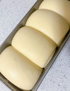 four loaves of bread sitting in a pan