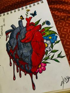 a drawing of a heart with flowers and butterflies on it, next to a notepad