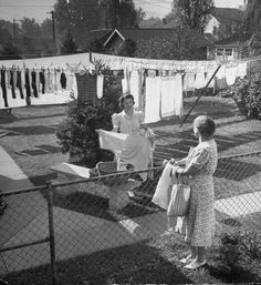 an old photo of two women hanging laundry outside