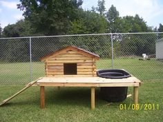 a dog house with a trash can in the yard