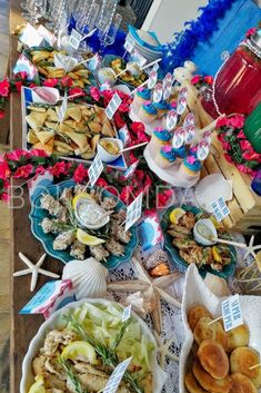 an assortment of food is on display at a beach themed party with blue and red decorations