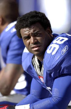 a close up of a football player sitting on the sidelines