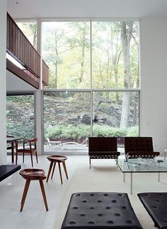 a living room filled with furniture and large windows