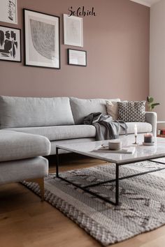 a living room with couches, tables and pictures on the wall above them is shown