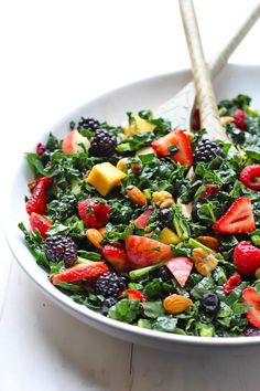 a white bowl filled with fruit and greens