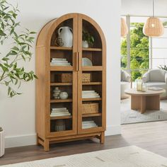 a wooden bookcase with wicker baskets on the front and bottom shelves, in a living room