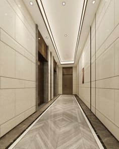 an empty hallway with white walls and marble flooring on both sides is lit by recessed lights