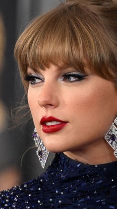 taylor swift wearing red lipstick and earrings at the oscars