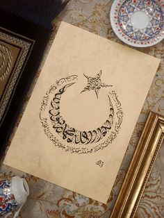 an arabic calligraphy is displayed on a table