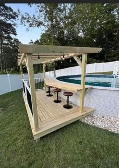 a wooden deck next to a swimming pool in a backyard with an above ground hot tub