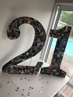 the number twenty two is covered with photos and confetti as it sits in front of a window