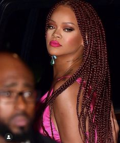 a woman with long braids standing next to a man