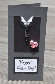 a card with a tie and two paper hearts