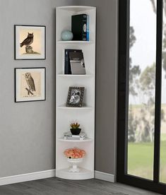 a corner shelf with books and pictures on it