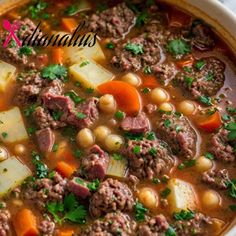 a close up of a bowl of soup with meat and vegetables on the side,