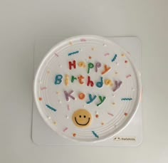 a happy birthday cake with sprinkles and a smiley face on the top