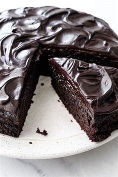 a chocolate cake on a plate with one slice cut out