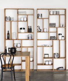 two wooden shelves filled with different types of items on top of each other in front of a white wall