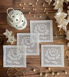 three crocheted placemats on a wooden table next to some white flowers