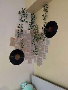 there is a record hanging from the wall with plants growing out of it and vinyl records attached to the wall