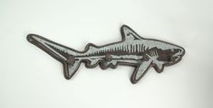 a shark shaped metal object on a white background