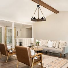 a living room filled with furniture and a chandelier hanging over the top of it