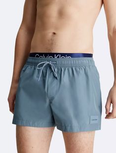 Crafted completely from recycled polyester, these swim shorts are made with reduced environmental impact. Designed with a double waistband and a drawstring closure. Features slip pockets at the sides and detailed with Calvin Klein logo styling at the waist. Fashion Logo, Environmental Impact, Swim Shorts, Calvin Klein, Swimming