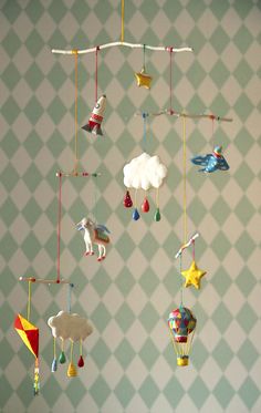 a mobile with animals and kites hanging from it's sides on a wall