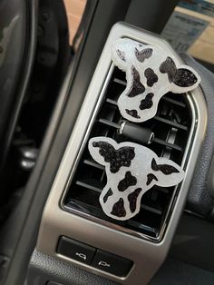 two cow stickers on the center console of a car