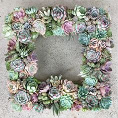 a wreath made out of succulents on concrete