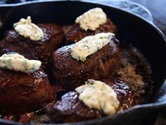 some steaks are cooking in a skillet with sauce on them and garnished with parsley