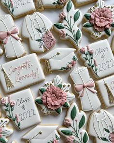 decorated cookies are arranged on a table for a graduation party with flowers and mortars